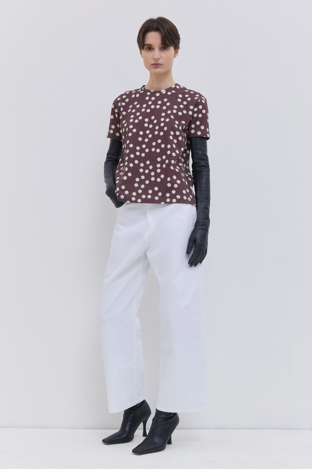 Side view of optical white wide-leg denim trousers with a cropped length.