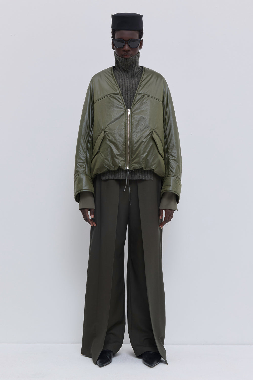 Olive Jelana V-neck padded jacket with subtle sheen, front zipper and adjustable hem detail.