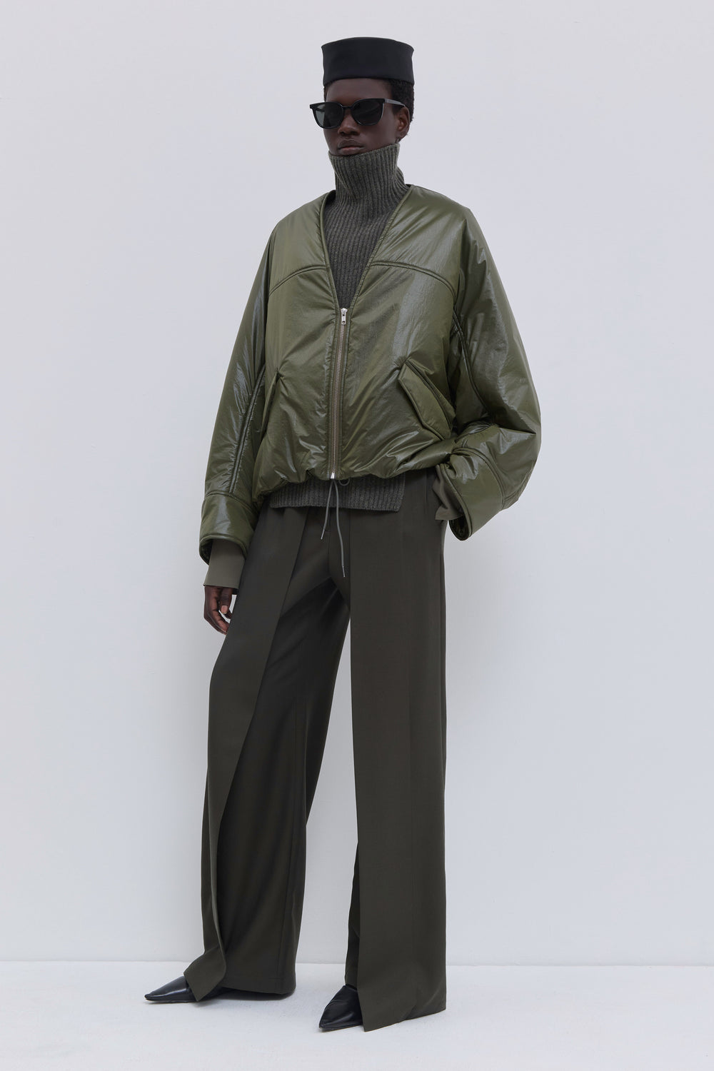 Olive Jelana padded jacket styled open over a ribbed turtleneck knit and wide-leg tailored trousers