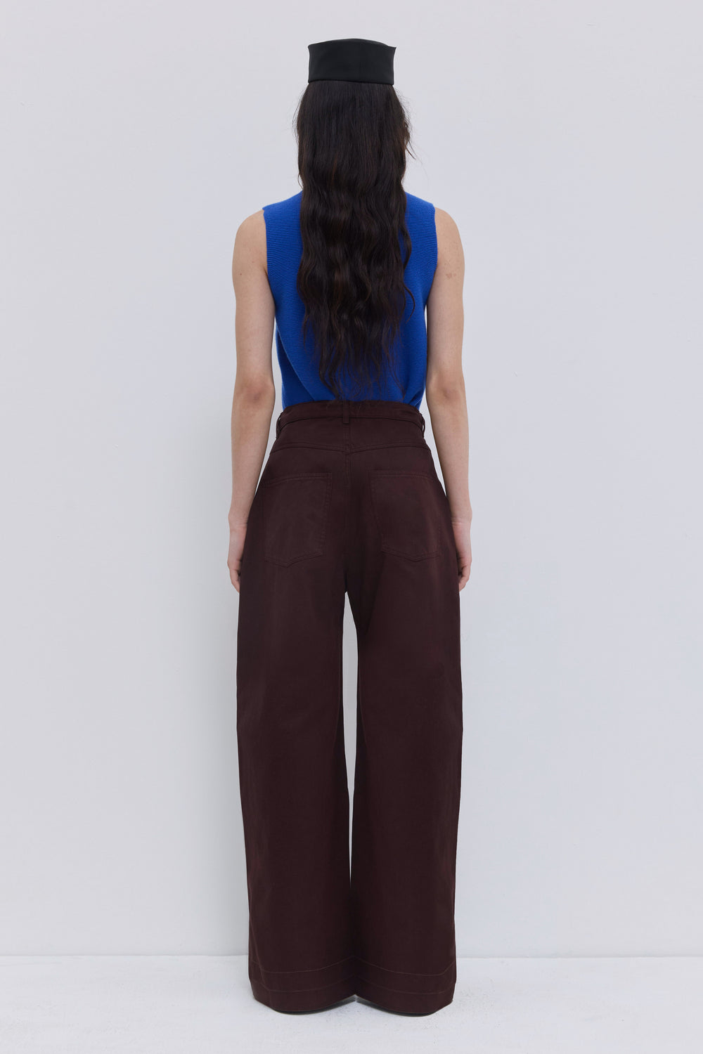 Back view of the Piros trousers in garment-dyed plum organic cotton with oversized barrel legs and patch pockets.