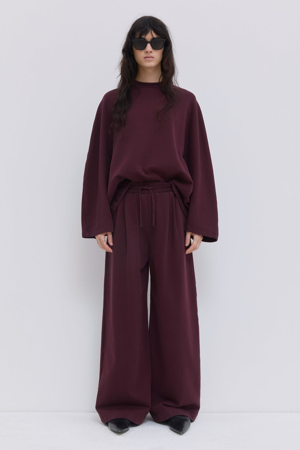 Pishas burgundy garment-dyed jersey sweatpants with wide-leg fit.