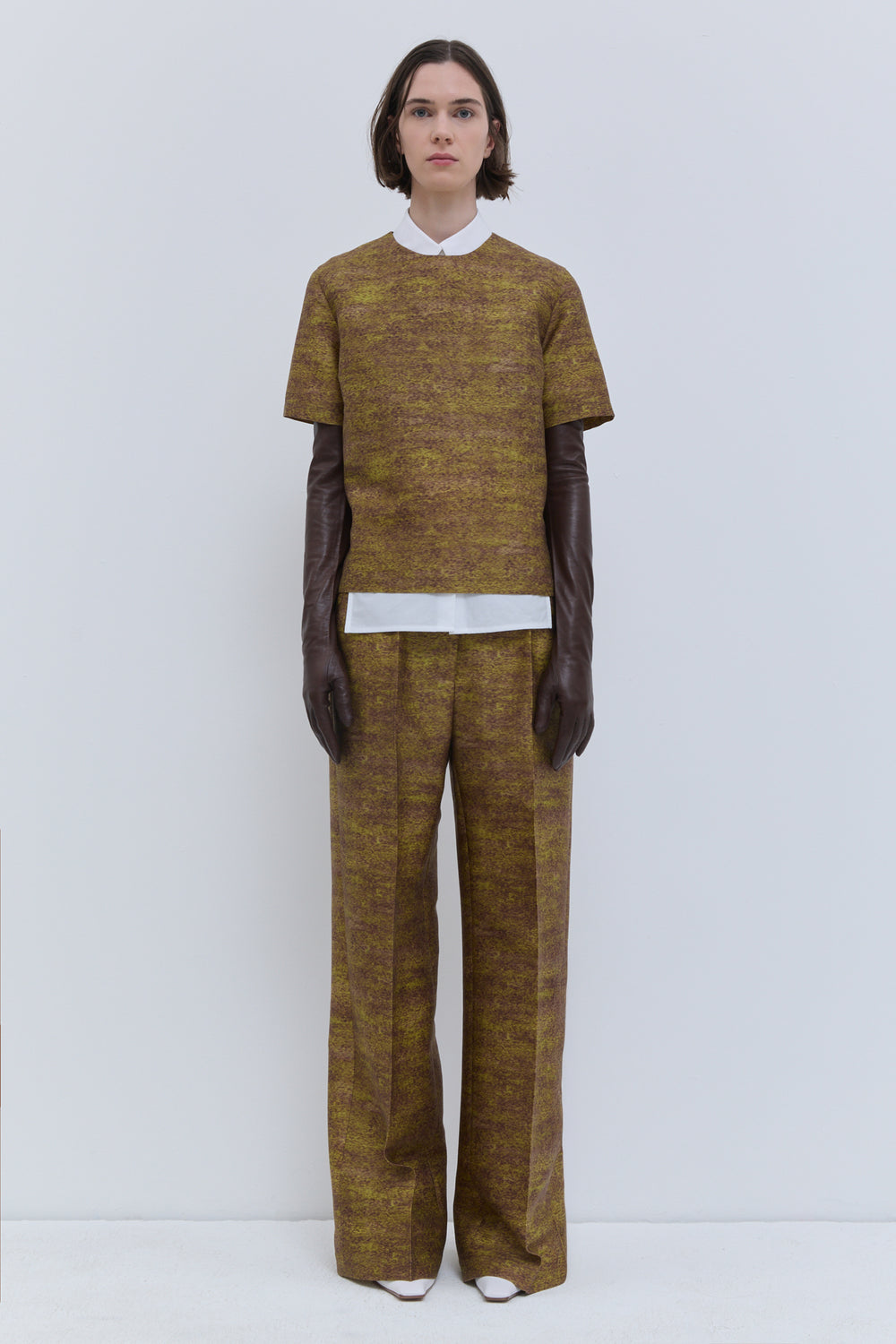 Front view of the Gold Storm printed wool and silk fitted short-sleeve top with side slits.